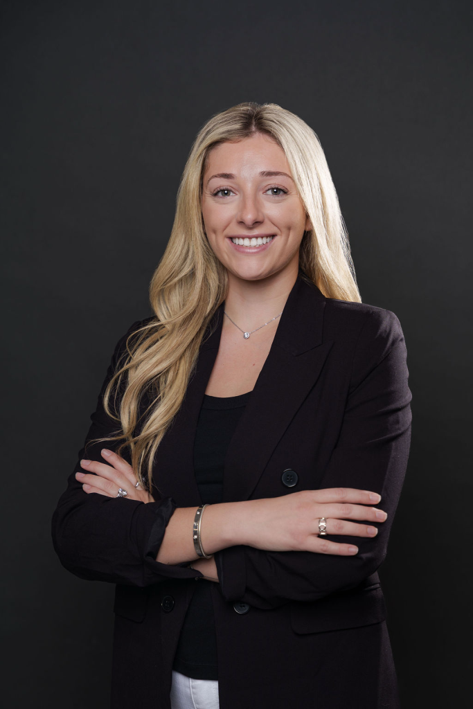 A professional looking  woman with a black top and arms crossed. Pictured is Aspen Noonan- CEO of Elevate Holistics 